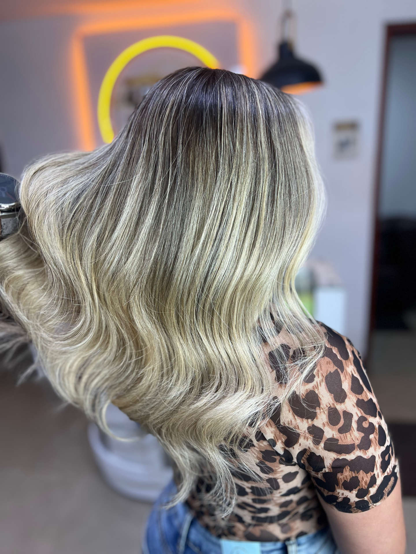 Rubio iluminado con raíz difuminada y ondas voluminosas